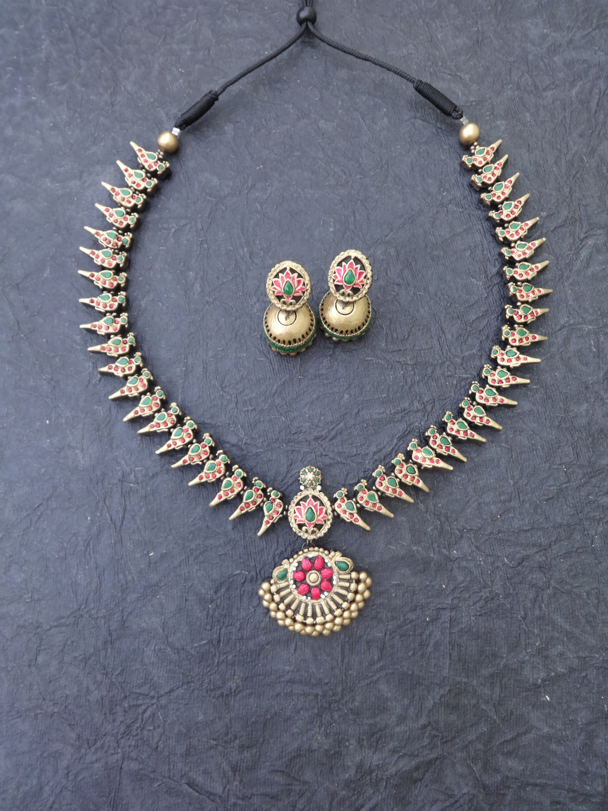 Jewelry set with necklace and earrings on a dark textured background