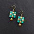 Handcrafted turquoise and gold geometric grid terracotta jewellery drop earrings with metallic beads on black slate